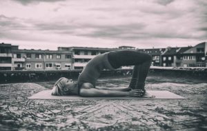 Woman does bridge pose on roof