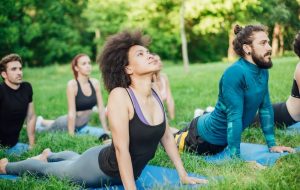 Woman outside doing cobra pose with group