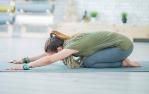 Woman doing childs pose stretch outside