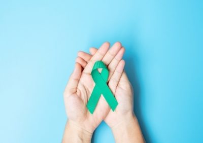 Womens hands holding ovarian cancer awareness ribbon