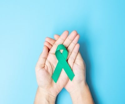 Womens hands holding ovarian cancer awareness ribbon