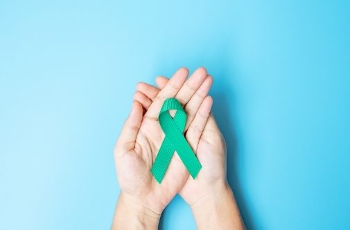 Womens hands holding ovarian cancer awareness ribbon