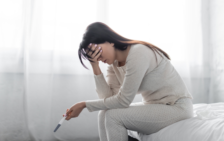 A woman holding a negative pregnancy test.